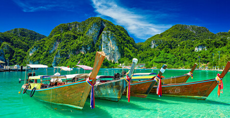 koh phi phi thailand with long tail boats floating on crystal clear water - 620654348