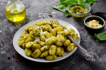 Gnocchi with Pesto, Potato Gnocchi Tossed with Basil Pesto Sauce, Italian Cuisine, Tasty Meal over Dark Background