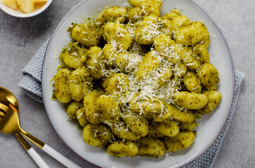 Gnocchi with Pesto, Potato Gnocchi Tossed with Basil Pesto Sauce, Italian Cuisine, Tasty Meal over Light Grey Background
