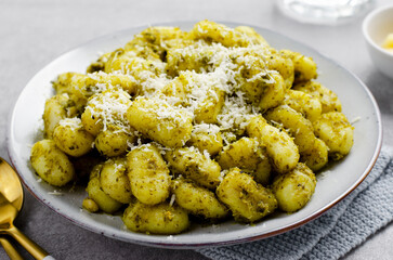 Gnocchi with Pesto, Potato Gnocchi Tossed with Basil Pesto Sauce, Italian Cuisine, Tasty Meal over Light Grey Background