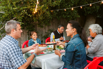 Diverse Family eating together in patio