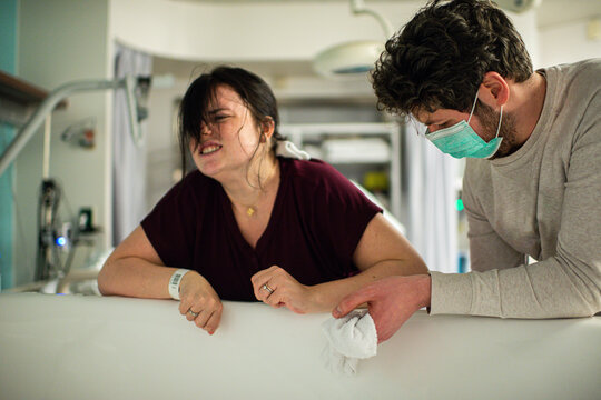 woman with contractions leaning on bath tub in hospital
