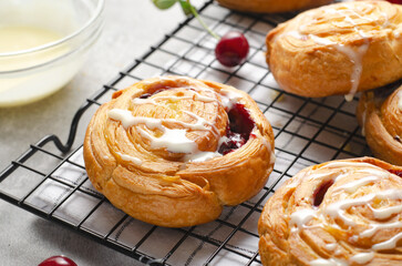 Freshly Baked Puff Pastry with Cherry and Sweet Glaze on Bright Grey Background