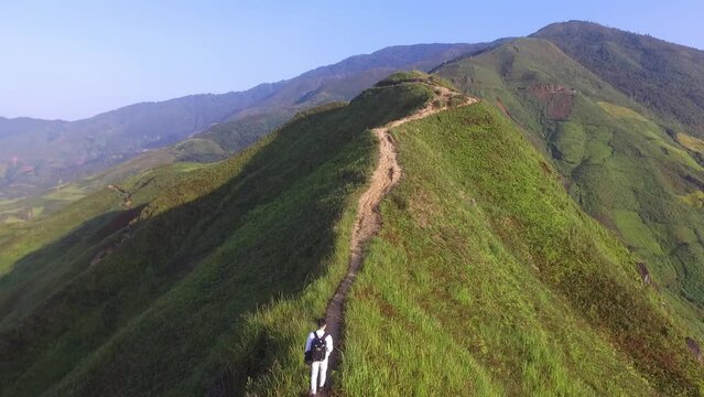 A young boy is walking on dinosaur mountain Ta Xua., Vietnam