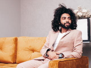 Handsome smiling hipster model. Unshaven Arabian man dressed in elegant beige suit . Fashion male...