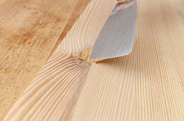 The process of puttying a wooden board. Spatula, putty, wooden board. Carpentry works.