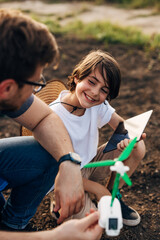 Closeup view of a happy young boy playing with his father in the garden.