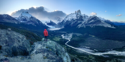 Man on cliff overlooking epic Fitz Roy Patagonia mountain range