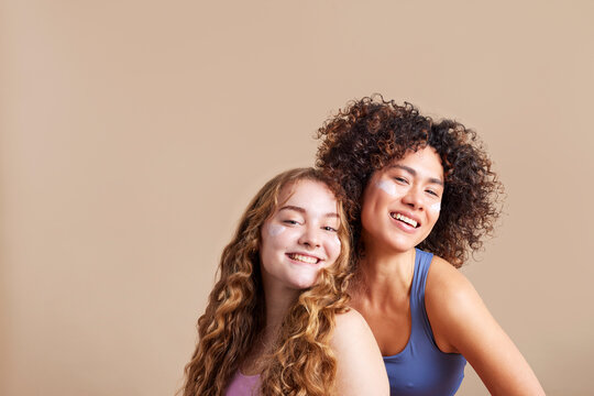 Joyful diverse teen girls smiling at camera in studio