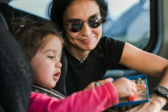 Backseat Adventures: Mother Entertaining Her Daughter in the Car