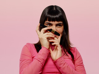 Happy woman covering her face with make up product