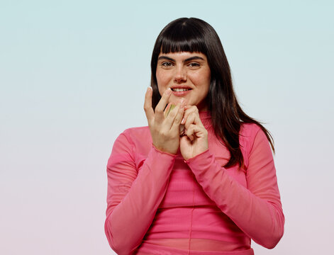 Happy woman smiling with skin care product in her finger
