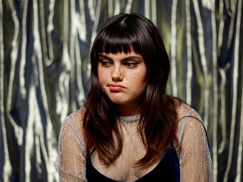 Woman with upset expression at shiny party studio portrait
