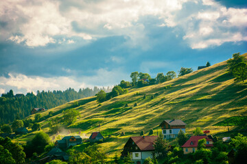 Naklejka premium Sunlight plays on the slopes of green mountains, the magic of nature, light. High quality photo