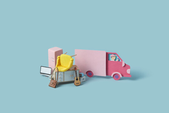 Miniature furniture stacked in front of paper craft truck.