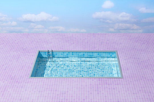 Swimming pool against pink tiles and blue sky background.