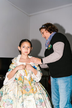 Woman preparing girl for Valencia Fallas