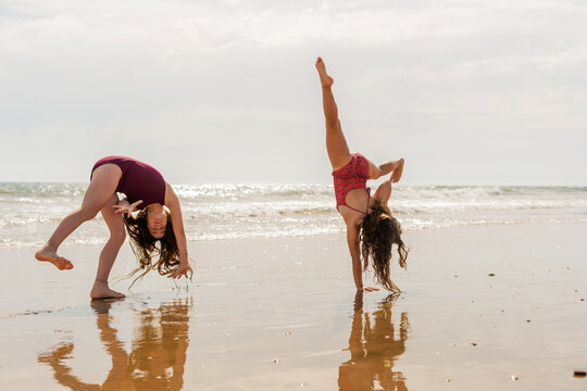 Girls doing somersaults by the seashore