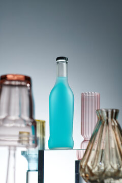 Select a focus soda bottle with colorful glasses goblet around