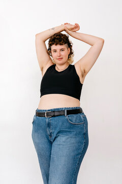 Happy non binary person with plump body raising arms