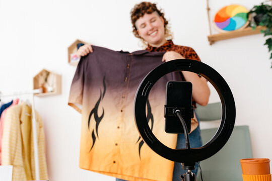 Cheerful queer recording fashion vide on smartphone