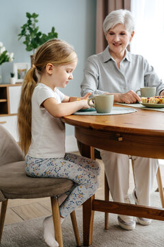 Little girl having breakfast with granny