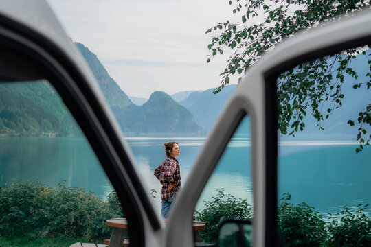Woman looking at the fjord while making a stop during road trip