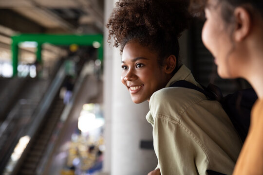 Female student smiling while standing at railing