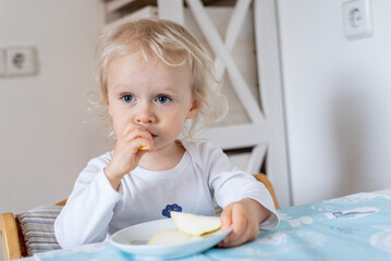 Portrait of little child eating pear