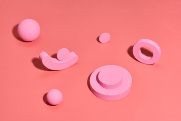 Geometric concrete figure and stones on coral color background