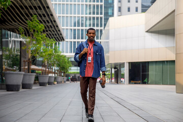 Smiling man carrying backpack on urban city street going to office 