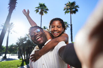 Cheerful selfie of a young African American couple on their summer vacation on an island. African...