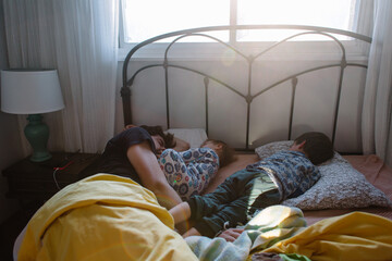 Family wakes up in early morning in bed