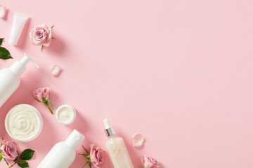 Skin care natural cosmetics set with roses on pink background. Flat lay, top view.