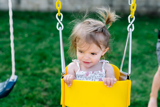 Toddler sitting in baby swing