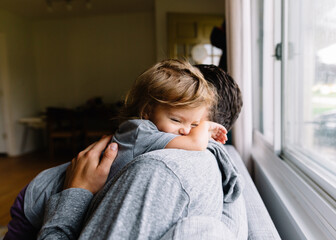 Toddler and Father hug on couch