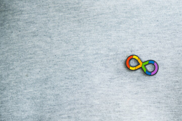 Teenage boy with autism infinity rainbow symbol sign metallic pin brooch on t-shirt. World autism...