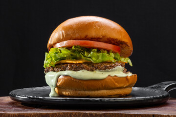 .Traditional hamburger, bread, burger meat, melted cheese, lettuce, tomato and mayonnaise - obrazy, fototapety, plakaty