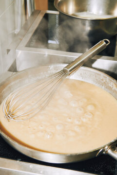 bechamel sauce simmering in a frying pan
