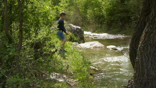 Young boy throwing stones in a river