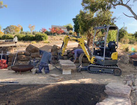 Landscape Architect and worker making seating area in garden