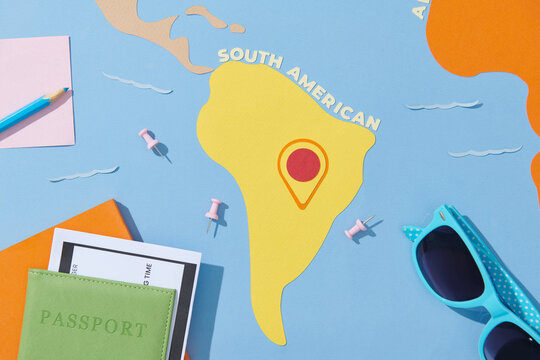 Traveller's accessories on world map background, top view.