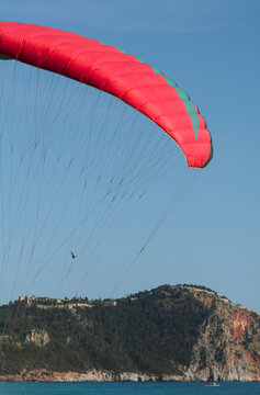 An abstract view of a paraglider against a blue sky and mountain.