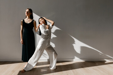 Confident ballerina dancing with partner in studio