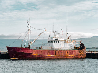 Old rusty fishing boat parked in the Icelandic harbour