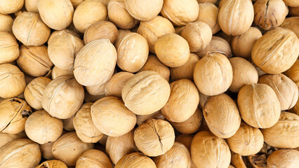 Background of ripe whole walnuts. Nuts on the market counter.