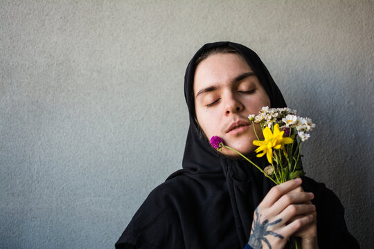 Queer muslim person with bouquet of flowers