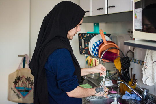 Muslim person doing the dishes 