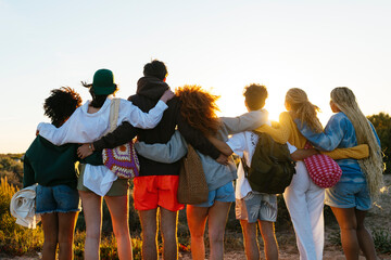 Group of diverse friends spending time together at sunset