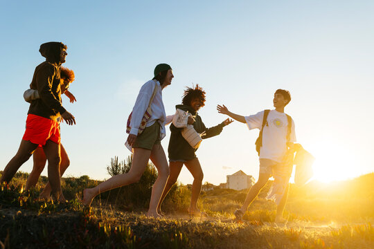 Group of friends walking on sandy beach